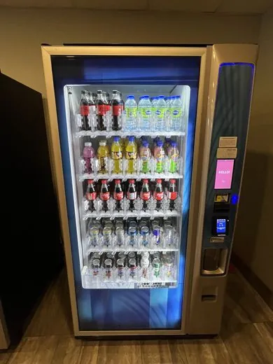Rows of bottled drinks stocked inside an open beverage vending machine