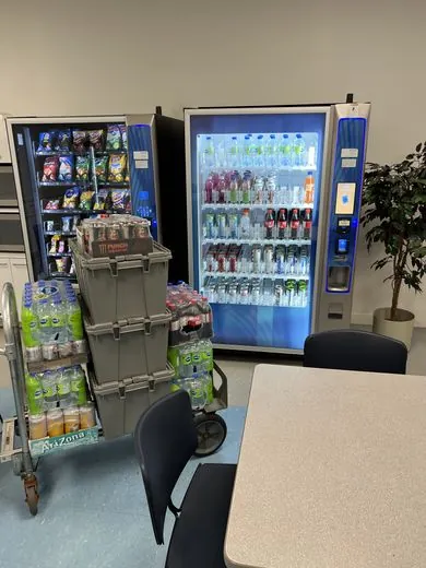 Glass-front snack and drink vending machines in a staff breakroom