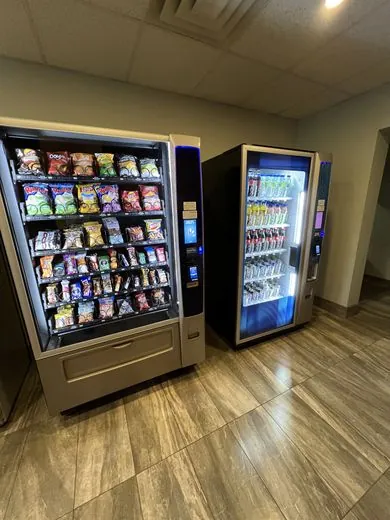 Glass-front snack and beverage coolers installed in a workplace hallway